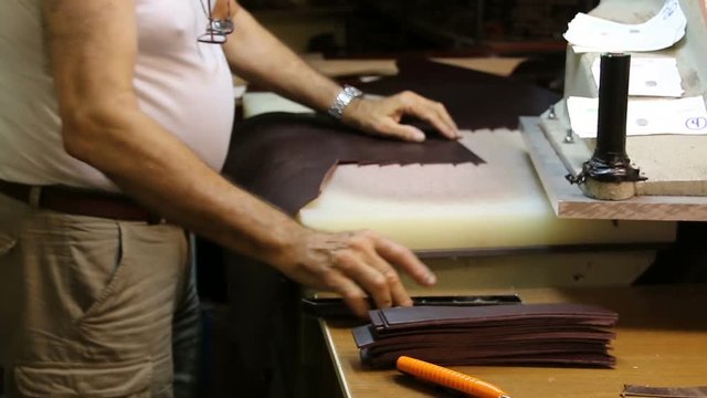 Work shoemaker makes sandals. Shoemaker works with leather on the machine.