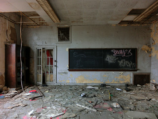 Vintage old destroyed classroom inside abandoned school with chalk board