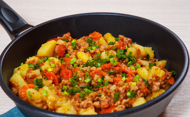 stewed potato with minced meat in a frying pan