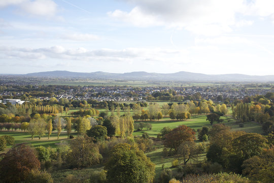 Abergele British Village In Wales, Overlooking The Town With Mountains On The Horizon, Showing Trees, Fields And Traffic From A High Distant Vantage Point.