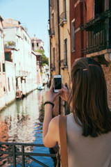 Fototapeta na wymiar Young girl take a photo in Venice, Italy. Beautiful place