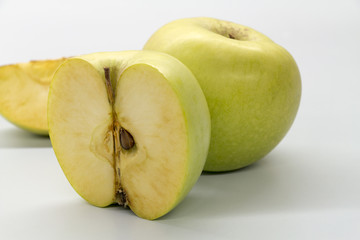 Sliced green apples on a white table.