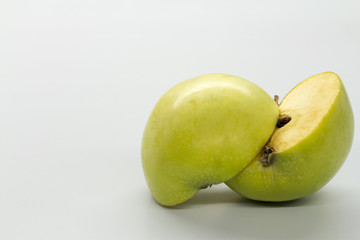 Sliced green apples on a white table.