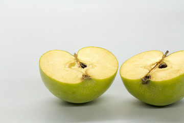 Sliced green apples on a white table.