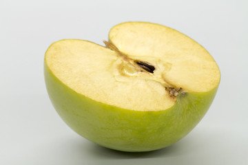 Sliced green apples on a white table.