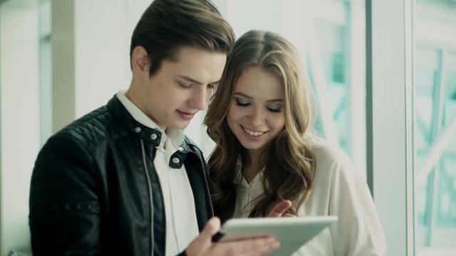 Young man and woman.They are discussing some business matters using tablet computer