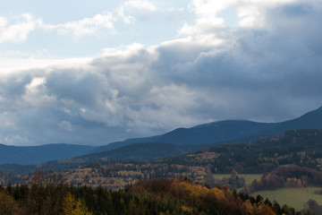 Summer landscape and the dark blue sky with clouds in mountains