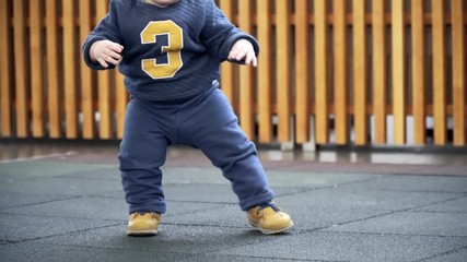 One year old baby standing up on his own.