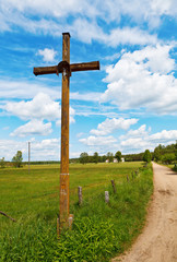 Fototapeta na wymiar Figurine of Jesus on the cross by rural road