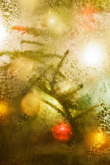Decorated and illuminated Christmas tree on indistinct, blurred and  fairytale background.
