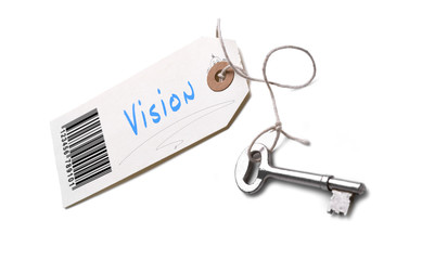 A silver key with a tag attached with a Vision concept written on it.