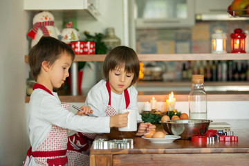 Two sweet children, boy brothers, preparing gingerbread cookies
