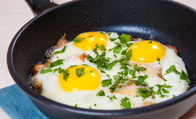 fried eggs with bacon in a frying pan