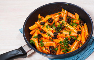 Penne pasta with tomato sauce in a frying pan