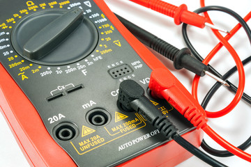 Digital multimeter with probes on a white background