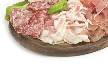 wooden cutting board with salami and salad