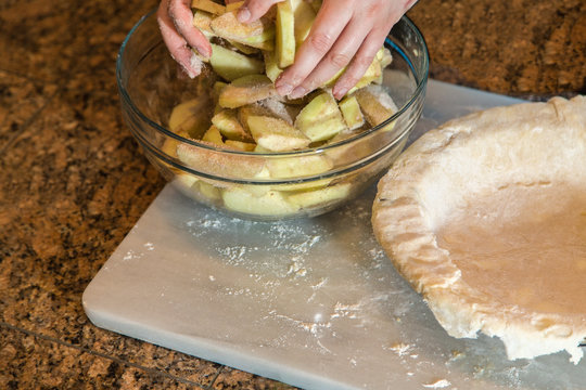 Hands in a Bowl of Fresh Apples, About to Load Into a Pie Crust