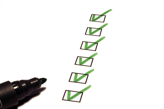 Checkliste mit gr&uuml;nen Hacken und Stift