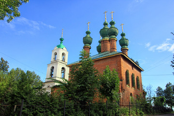 old beautiful red-brick Russian Orthodox Church with its green d