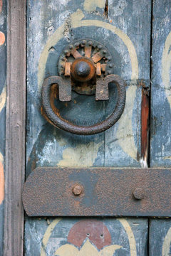 old medieval metal rusty door knocker on old color wooden door c