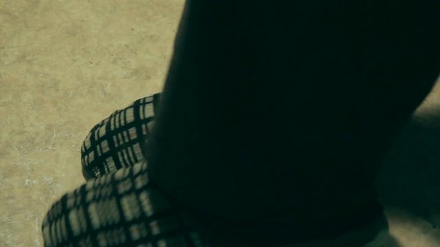 An elderly man in old slipers