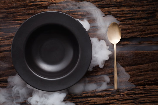 black empty bowl spoon on wooden table background