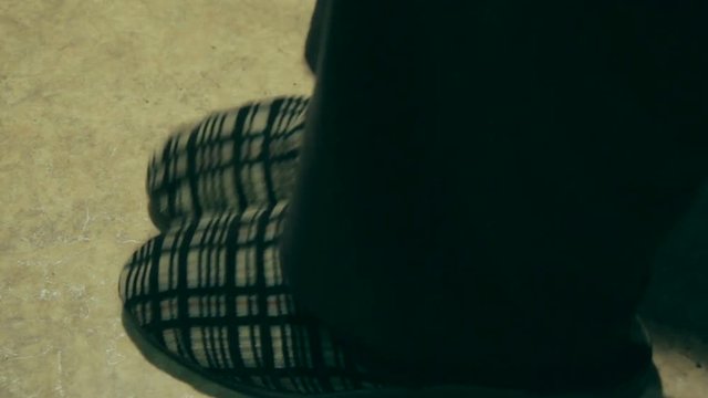 An elderly man in old slipers