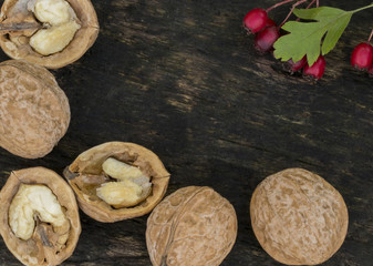 Walnuts. Macro . Nut and red berries. Wooden background