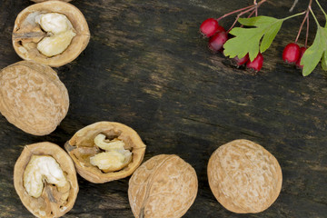 Walnuts. Macro . Nut and red berries. Wooden background