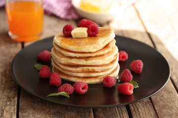 Plate full of tasty pancakes with raspberries