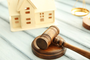 Gavel and miniature house on wooden background. Auction concept