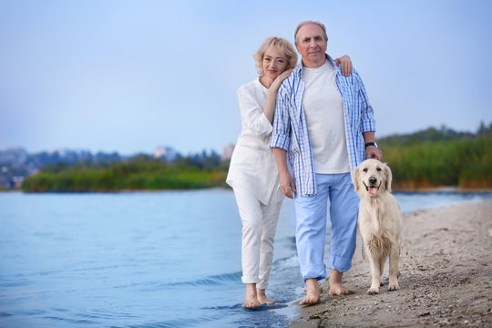 Senior couple and big dog on riverside