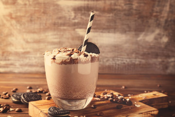 Delicious milkshake with chocolate, coffee and cookies on wooden background