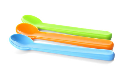 Colorful plastic spoons for child on white background