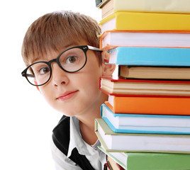 Cute schoolboy and heap of books on white background, closeup