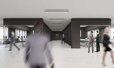 People walking in office with black and glass walls