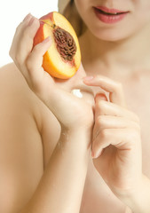 Half of peach in female hands
