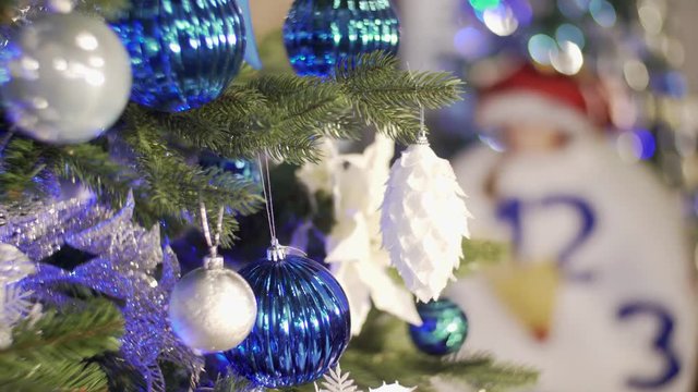 Christmas tree decorated with bright blue garlands and toys.Christmas tree decorated with bright blue garlands and toys. the fir-tree decorated with blue toys. A big beautiful fir-tree with New Year's