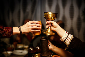people clink cups on a medieval feast.