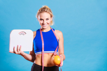 Fit woman holds weight scale grapefruit