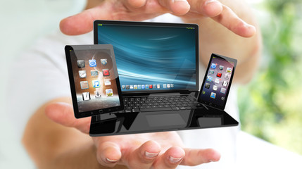 Businessman holding laptop phone and tablet in his hand 3D rende