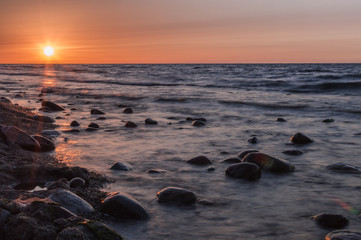 Fototapeta na wymiar Sunset over the sea. Stone on the foreground.