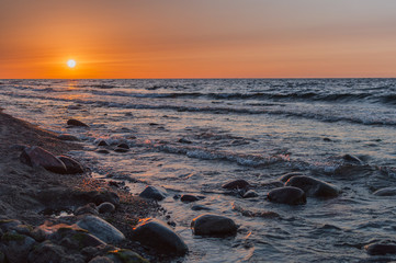 Obraz premium Sunset over the sea. Stone on the foreground.