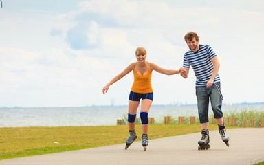 Young couple on roller skates riding outdoors