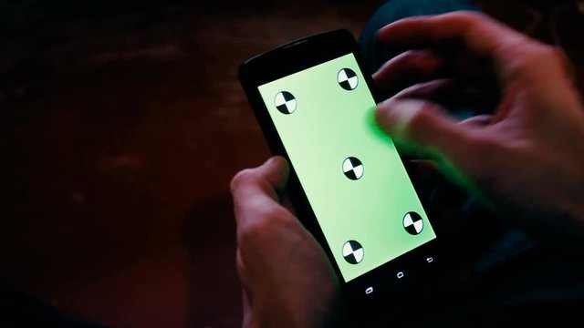 a young man and a green screen smartphone