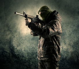 Portrait of a heavily armed masked soldier with grungy backgroun