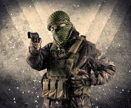 Portrait of a dangerous masked armed soldier with grungy backgro