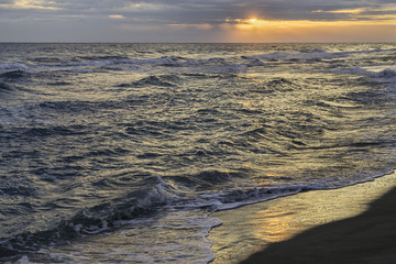 Bright dawn over Mediterranean Sea with sand beach
