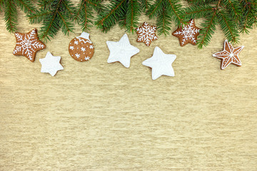 christmas gingerbread decorations with green fir tree branches on golden background