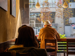 One elderly man who sat at the counter drinking coffee bar, coffee shop.